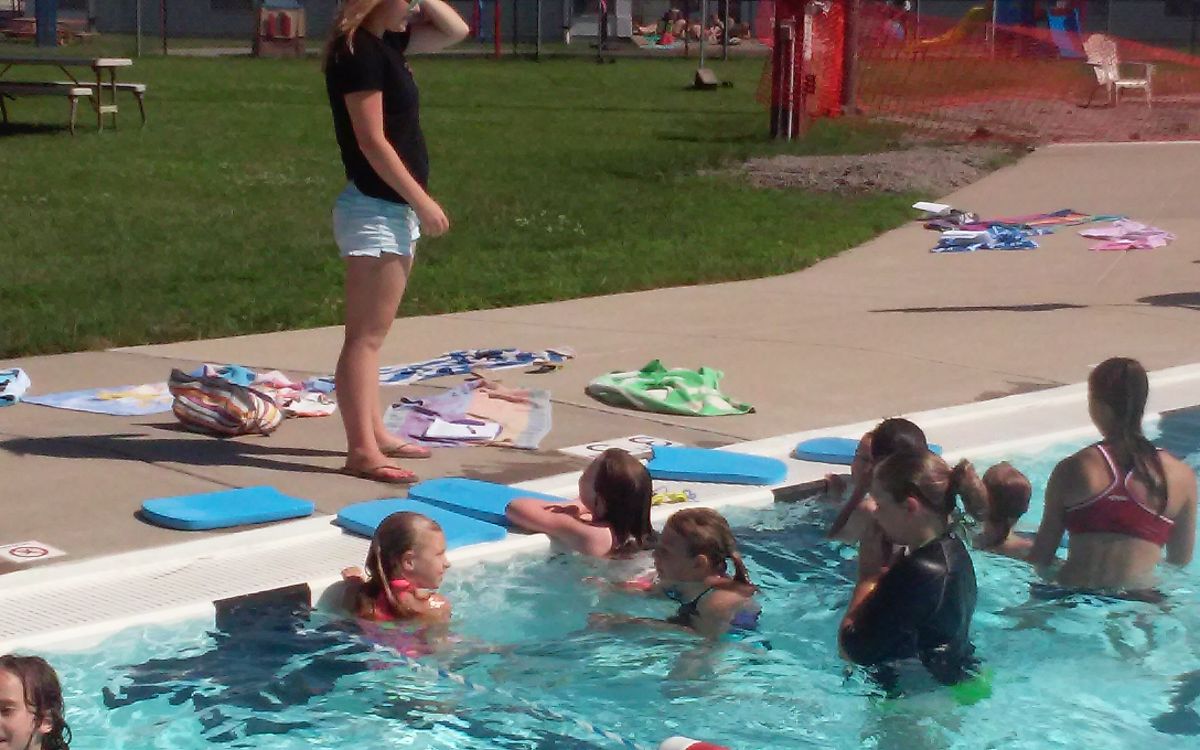 Image of Lady training kid swimmers